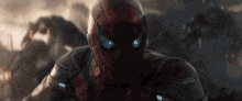 a close up of a person in a spiderman costume with blue eyes