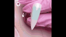 a person wearing pink gloves is holding a nail with a blue stripe on it .