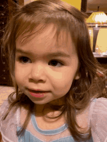 a little girl wearing a blue and white dress