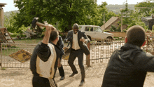 a man in a suit is being attacked by a group of men and the word prime is visible in the corner