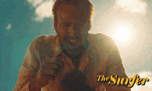 a poster for the movie the surfer shows a man with a beard