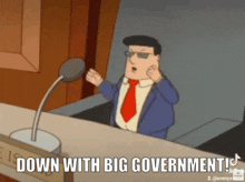 a man in a suit and tie is sitting in front of a microphone and saying down with big government .