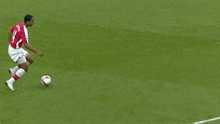 a soccer player wearing a red jersey with the name alvarez on the back is kicking the ball