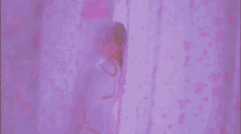 a woman is standing in front of a window in a purple room .