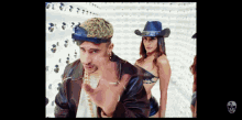 a man wearing a cowboy hat stands next to two women