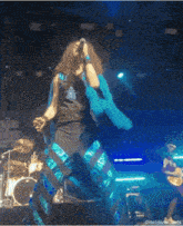 a woman in a blue outfit is singing into a microphone