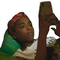 a woman wearing a head scarf looks at her cell phone