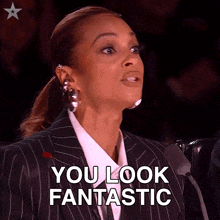 a woman in a suit and white shirt says you look fantastic