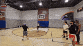 a group of men are playing basketball on a court with a sign that says " in your "