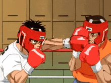 two men are boxing in a ring with red gloves .