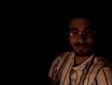 a close up of a man 's face wearing glasses and headphones .
