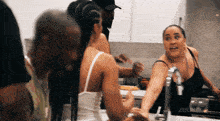 a group of people are gathered in a kitchen with the word zeus on the bottom right
