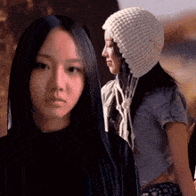 a woman with long black hair wearing a knitted hat