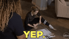a woman is sitting on the floor with the word yep written on it