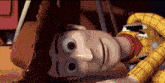 woody from toy story is laying down on the floor with his head down .