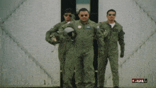 three men in military uniforms are walking in front of a wall that says full on it