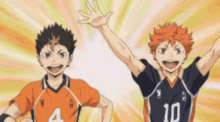 a couple of volleyball players standing next to each other with their arms in the air .