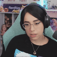 a woman wearing glasses and headphones sits in front of a renrize sign