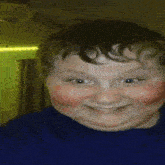 a young boy with red cheeks and a blue shirt makes a funny face