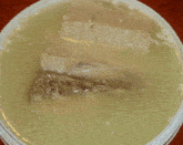 a piece of meat is floating in a container of liquid