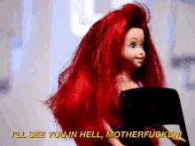 a barbie doll with red hair and blue eyes says " i 'll see you in hell motherfucker "