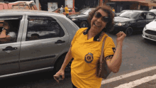 a woman wearing a yellow shirt with a lion 's club logo on it