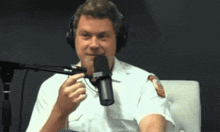 a man wearing headphones is talking into a microphone with a patch on his sleeve that says ' fire department '