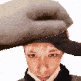a pixelated image of a person wearing a hat and a scarf