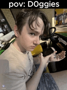a young man is holding a cell phone in his hand with the caption pov : doggies