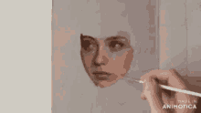 a person is painting a face with a brush on a canvas .