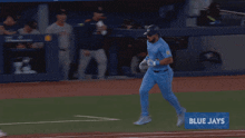 a baseball player in a blue uniform is running on the field with ue ja written on the bottom
