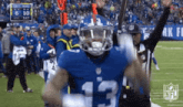 a football player with the number 13 on his jersey is celebrating