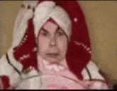 a man with a towel wrapped around his head is laying in bed .