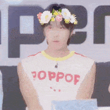 a man wearing a flower crown and a shirt that says poppop on it