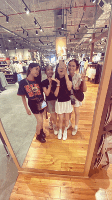 three girls are posing for a picture in front of a mirror with one wearing a shirt that says wolverines