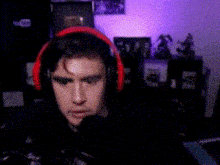 a man wearing headphones is sitting in front of a computer in a room .