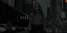 a woman is walking down a street with the name ennaz gill on the bottom