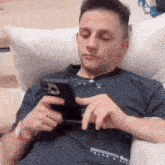 a man laying on a couch using a cell phone