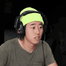 a young man wearing headphones and a neon yellow hat