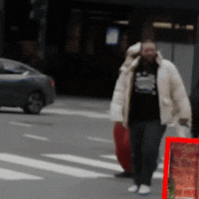 a man walking down a street with a red sign in front of him