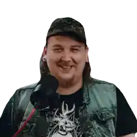 a man wearing a hat and a black shirt with a deer on it is smiling