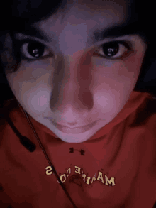 a close up of a person 's face with a red shirt that says ' aam ' on it