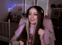a girl with long hair is wearing headphones and smiling