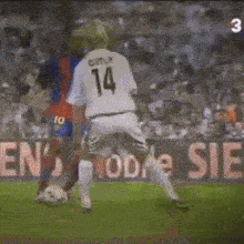 a soccer player with the number 14 on the back of his shirt
