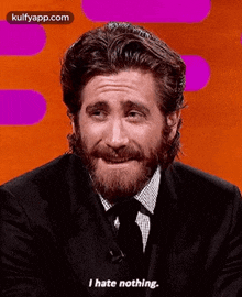 a man with a beard is wearing a suit and tie and says i hate nothing .