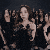 a woman wearing black lace gloves is surrounded by other women in black dresses