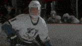 a hockey player wearing a white jersey with a duck on it
