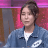 a woman wearing a denim jacket with a name tag that says ' ioi ' on it