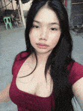 a woman in a red top takes a selfie with a green stool in the background