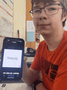 a boy wearing glasses holds up a cell phone with the word pornography on the screen